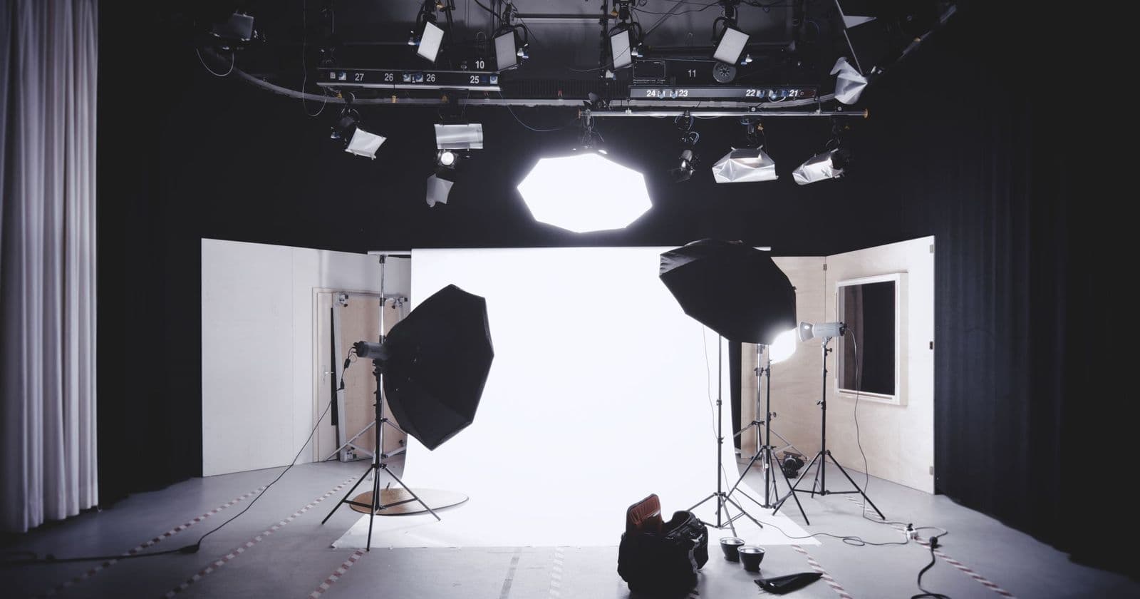 Stock photo: Empty video studio with overhead lighting rig, softboxes on stands and a white backdrop, no people